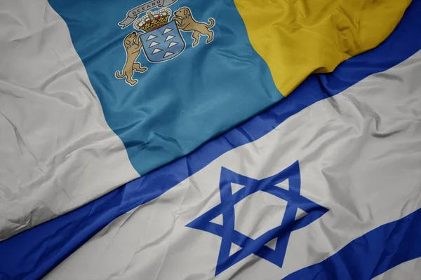 Ondeando colorida bandera de Israel y bandera nacional de las islas canarias . —  Fotos de Stock