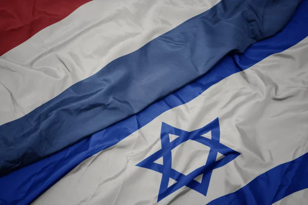 Agitant drapeau coloré d'Israël et drapeau national des Pays-Bas . — Photo