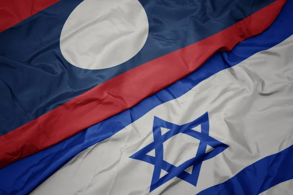 Ondeando colorida bandera de Israel y bandera nacional de laos . —  Fotos de Stock