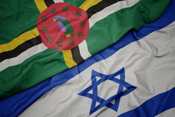 waving colorful flag of israel and national flag of dominica.
