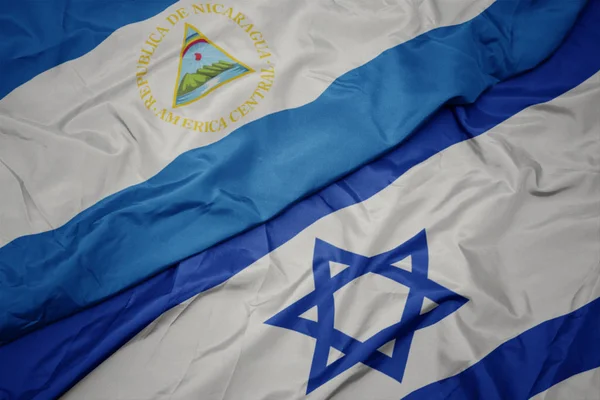 Ondeando colorida bandera de Israel y bandera nacional de nicaragua . —  Fotos de Stock