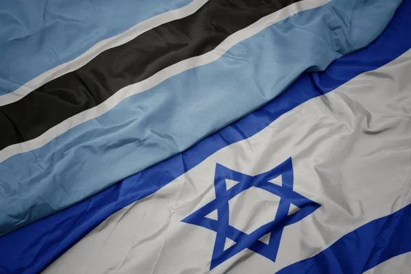 Agitant le drapeau coloré d'Israël et le drapeau national du Botswana . — Photo