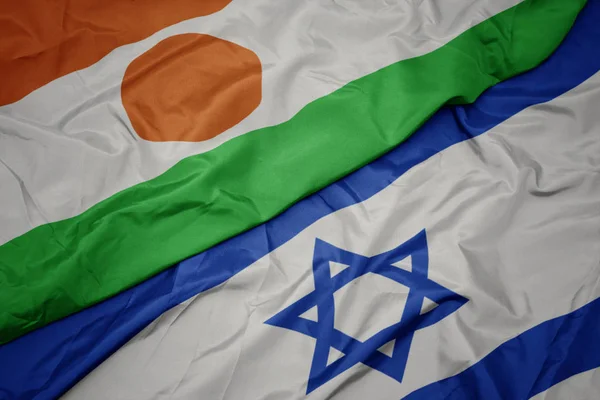 Agitant drapeau coloré d'Israël et drapeau national de niger . — Photo