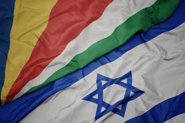 Ondeando colorida bandera de Israel y bandera nacional de Seychelles . —  Fotos de Stock