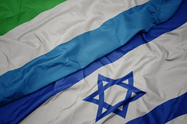 Agitant le drapeau coloré d'Israël et le drapeau national de la Sierra Leone . — Photo