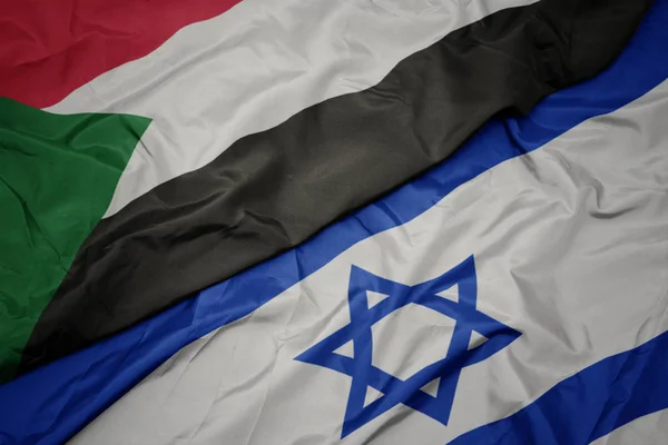 Falujące kolorowe flagi Izraela i flagi narodowej Sudanu. — Zdjęcie stockowe