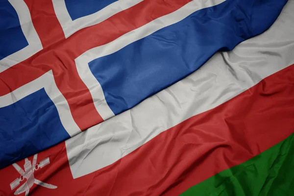 Sventolando bandiera colorata di oman e bandiera nazionale di iceland . — Foto Stock