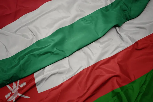 Omán, a magyar zászló színpompás zászlója integető. — Stock Fotó