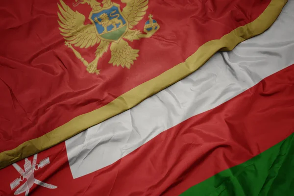 Zwaaiende kleurrijke vlag van Oman en de nationale vlag van Montenegro. — Stockfoto