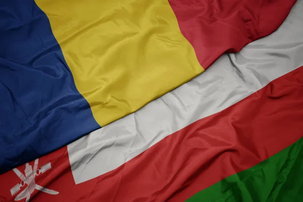 Umman renkli bayrak ve romanya ulusal bayrağı sallayarak. — Stok fotoğraf