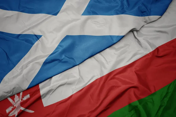 Waving colorful flag of oman and national flag of scotland. — Stock Photo, Image
