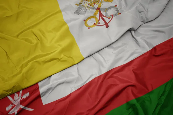Az Ománi zászló színpompás zászlaja és Vatikánváros zászlaja. — Stock Fotó