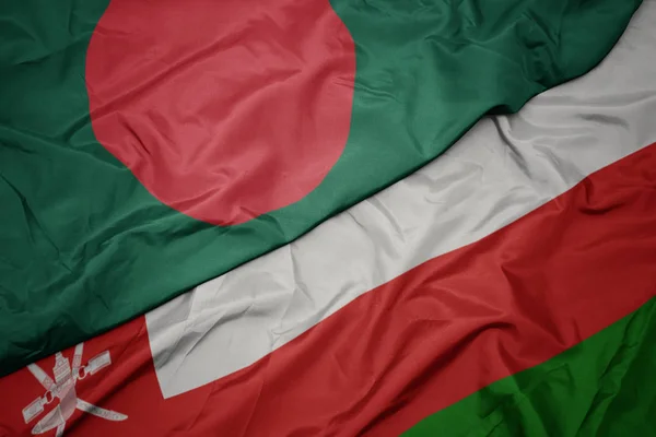 Sventolando bandiera colorata di oman e bandiera nazionale del bangladesh . — Foto Stock