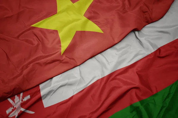 Waving colorful flag of oman and national flag of vietnam. — Stock Photo, Image