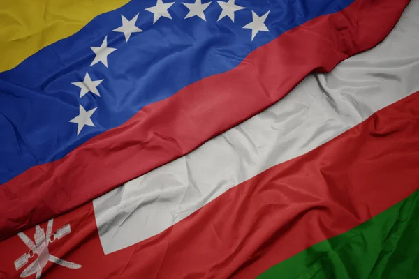 Waving colorful flag of oman and national flag of venezuela. — Stock Photo, Image