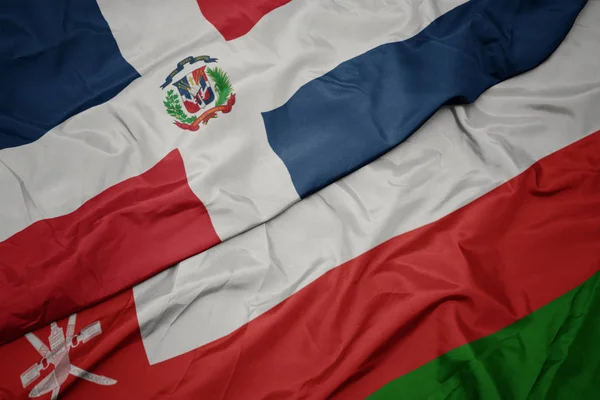 Umman renkli bayrak ve Dominik Cumhuriyeti ulusal bayrağı sallayarak. — Stok fotoğraf