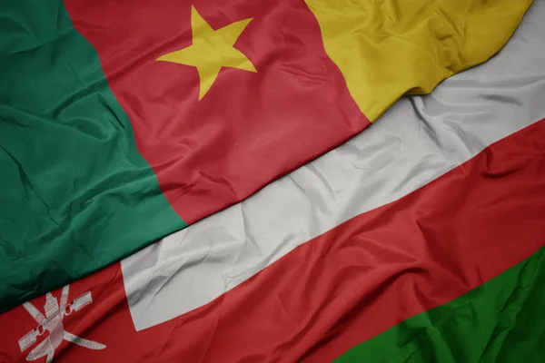 Ondeando colorida bandera de Omán y bandera nacional de Camerún . — Foto de Stock