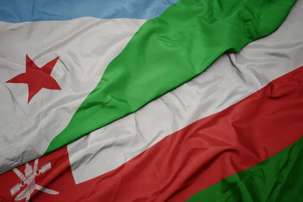 Umman renkli bayrak ve cibuti ulusal bayrak sallayarak. — Stok fotoğraf