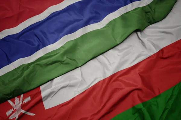 Waving colorful flag of oman and national flag of gambia. — Stock Photo, Image