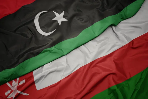 Waving colorful flag of oman and national flag of libya. — Stock Photo, Image