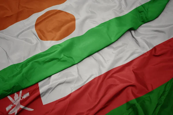 Ondeando colorida bandera de Omán y bandera nacional de Níger . —  Fotos de Stock