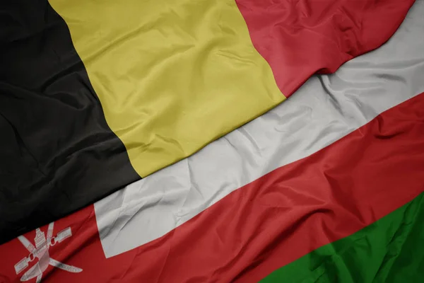 Waving colorful flag of oman and national flag of belgium. — Stock Photo, Image