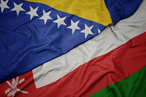 Acenando bandeira colorida de oman e bandeira nacional de bósnia e herzegóvina . — Fotografia de Stock