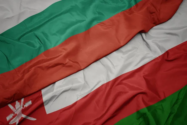 Umman renkli bayrak ve bulgaristan ulusal bayrağı sallayarak. — Stok fotoğraf