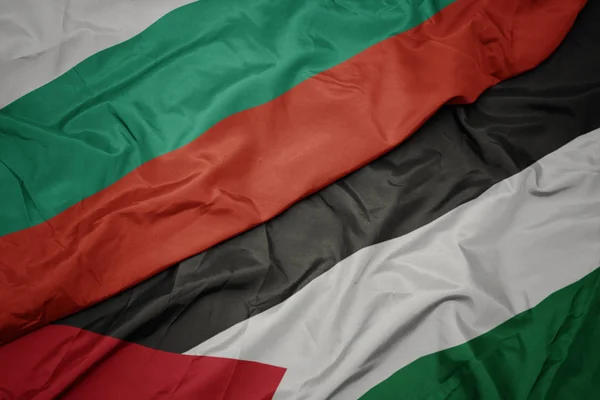 waving colorful flag of palestine and national flag of bulgaria