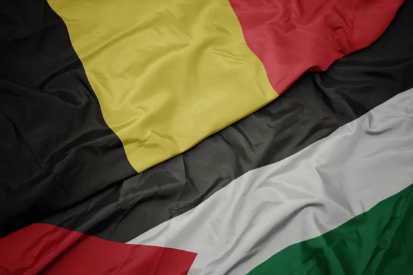 挥舞着五颜六色的巴勒斯坦国旗和比利时国旗. — 图库照片
