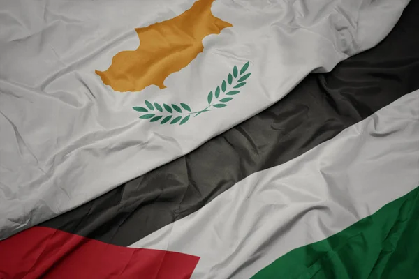 waving colorful flag of palestine and national flag of cyprus.