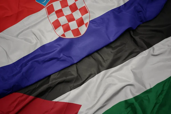 waving colorful flag of palestine and national flag of croatia.