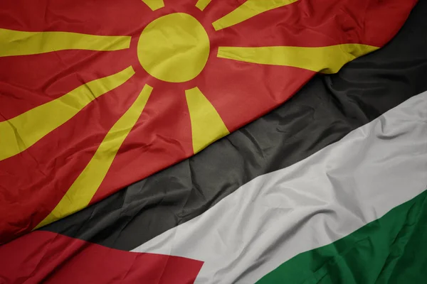 waving colorful flag of palestine and national flag of macedonia.