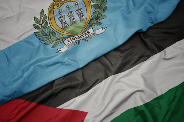 waving colorful flag of palestine and national flag of san marino.