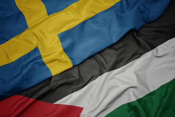 waving colorful flag of palestine and national flag of sweden.