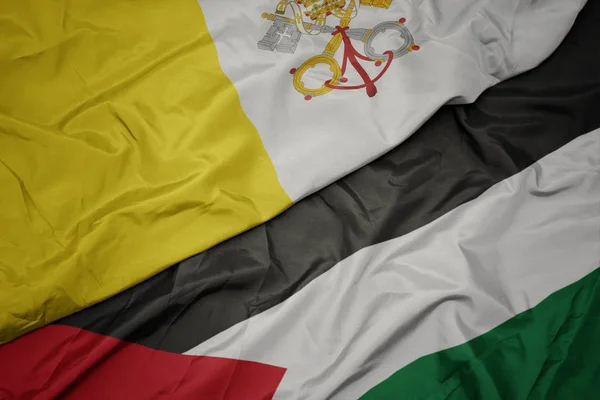 waving colorful flag of palestine and national flag of vatican city.
