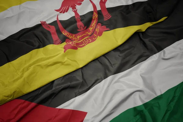 waving colorful flag of palestine and national flag of brunei.