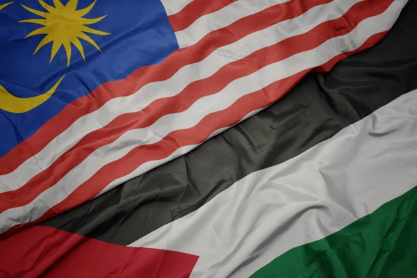waving colorful flag of palestine and national flag of malaysia.