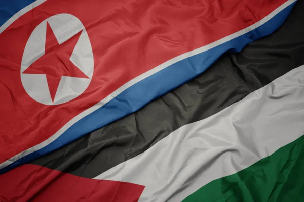 Ondeando colorida bandera de Palestina y bandera nacional de Corea del Norte . — Foto de Stock