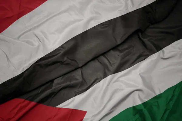 Acenando bandeira colorida da Palestina e bandeira nacional do Iêmen . — Fotografia de Stock