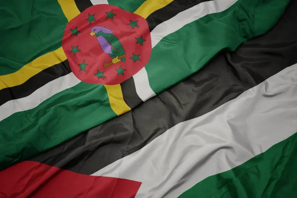 Schwenken bunte Flagge aus Palestin und Nationalflagge aus Dominica. — Stockfoto