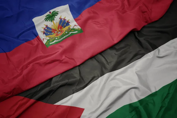 waving colorful flag of palestine and national flag of haiti.