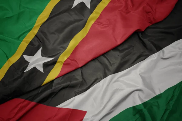 waving colorful flag of palestine and national flag of saint kitts and nevis.