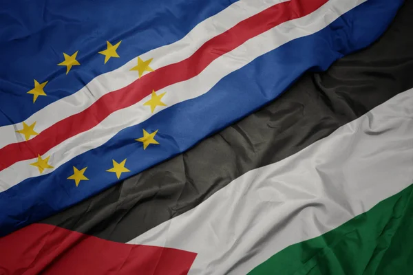 waving colorful flag of palestine and national flag of cape verde.