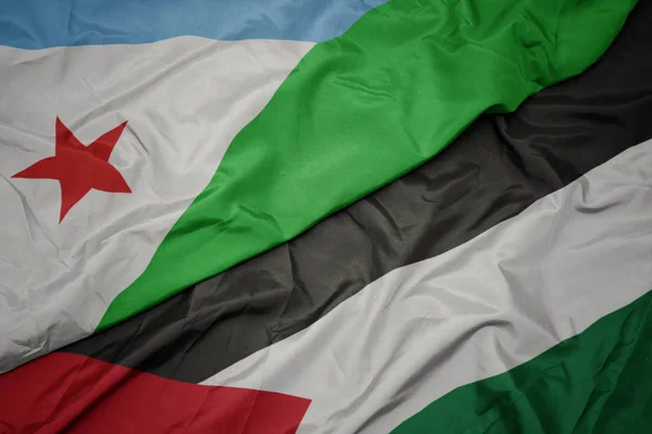 waving colorful flag of palestine and national flag of djibouti.