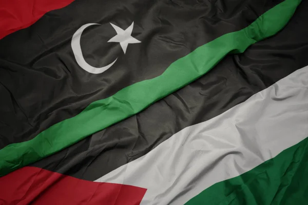 Waving colorful flag of palestine and national flag of libya. — Stock Photo, Image