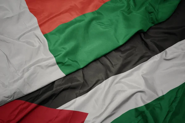 Waving colorful flag of palestine and national flag of madagascar. — Stock Photo, Image