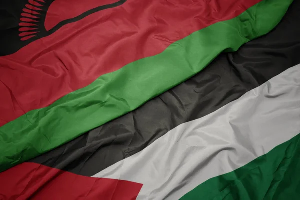 Agitant drapeau coloré de palestine et drapeau national de malawi . — Photo
