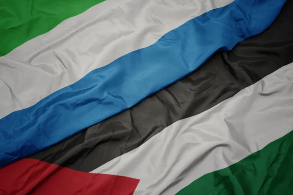 waving colorful flag of palestine and national flag of sierra leone.
