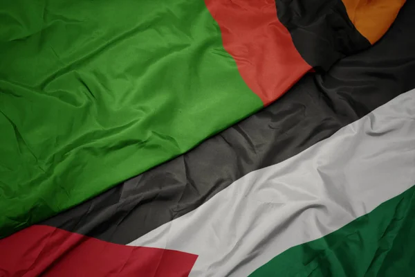 Acenando bandeira colorida da Palestina e bandeira nacional da zâmbia . — Fotografia de Stock